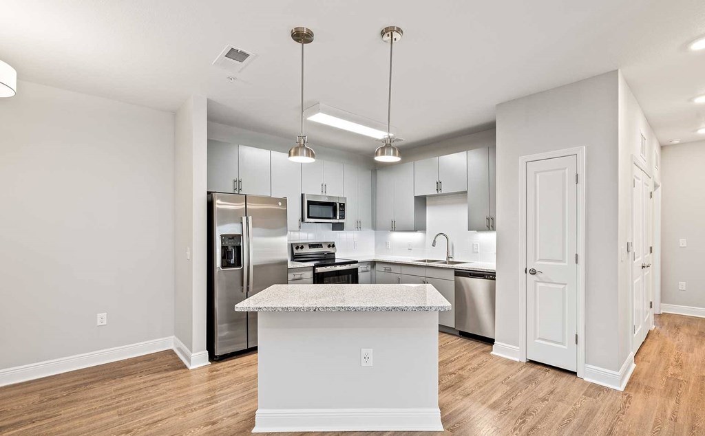 A kitchen with a white island in the middle.
