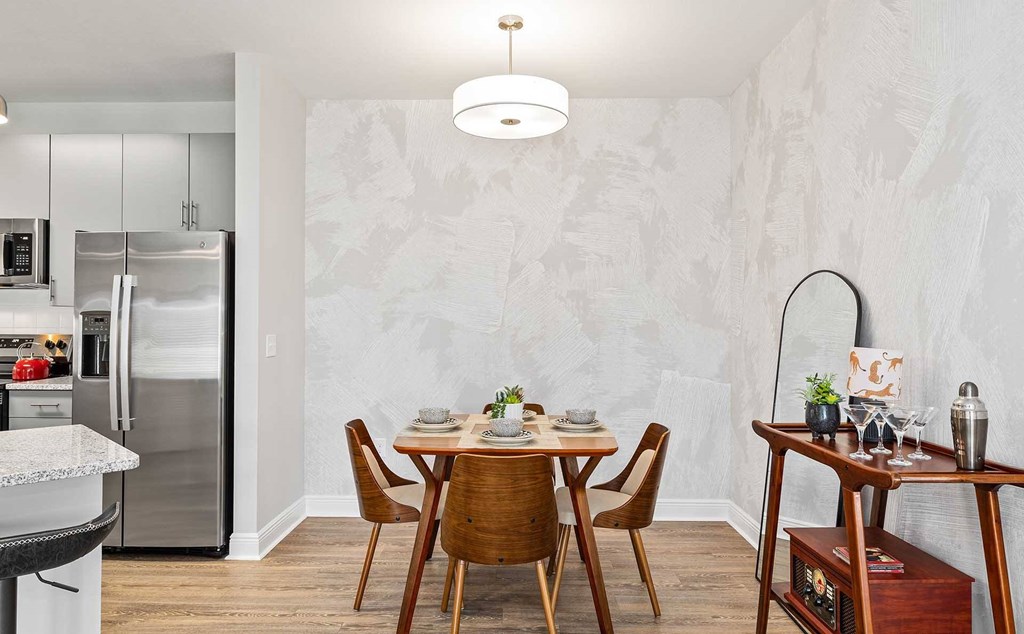 A modern kitchen with a dining table set for two.