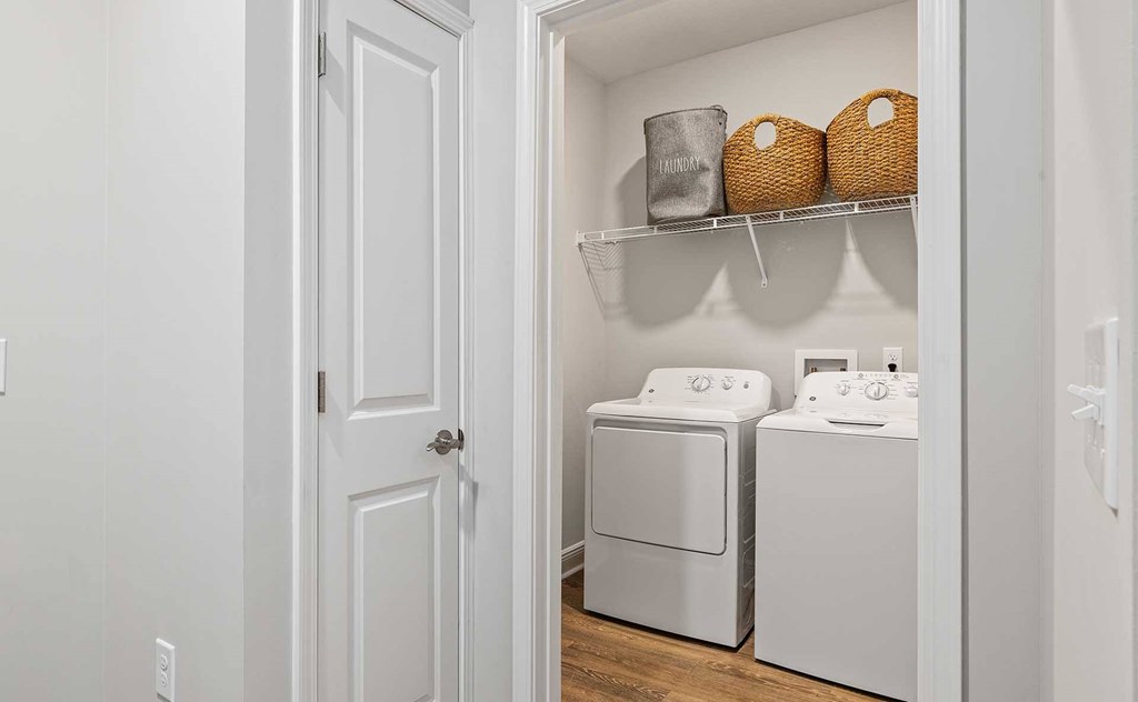 A white laundry room with a washer and dryer.