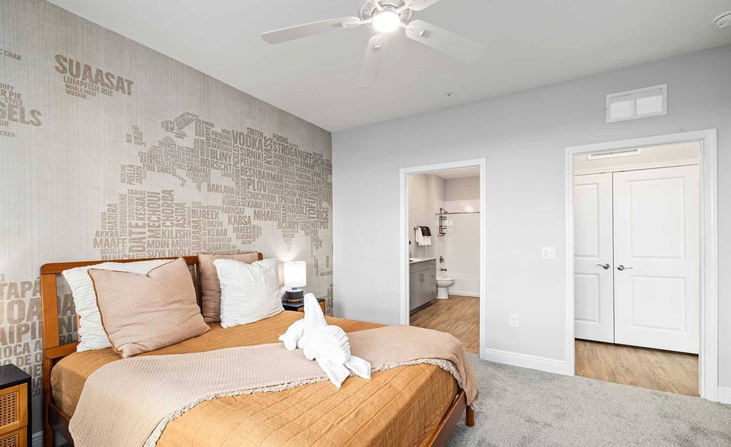 A bedroom with a bed, a ceiling fan, and a wall with a world map.