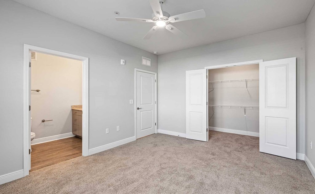 A room with a ceiling fan and a carpeted floor.