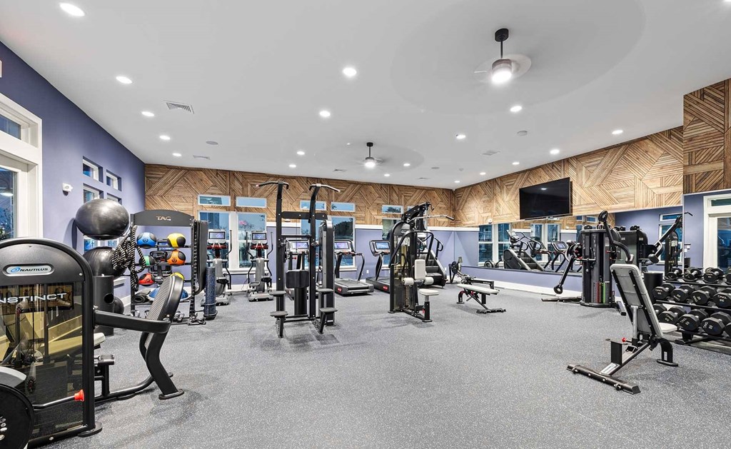 A spacious gym with a variety of equipment including treadmills, weights, and exercise machines.