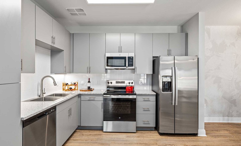 A modern kitchen with stainless steel appliances and white cabinets.