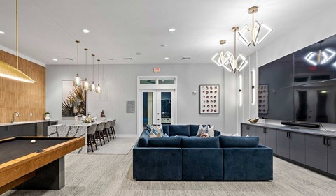 A modern living room with a pool table and a blue couch.