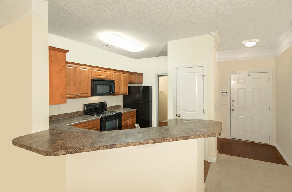 a kitchen with a granite counter top and a black refrigerator
