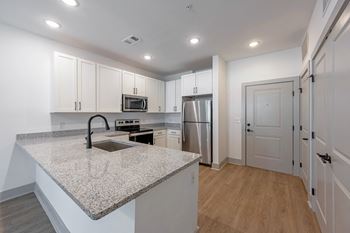 a kitchen with white cabinets and a granite counter top