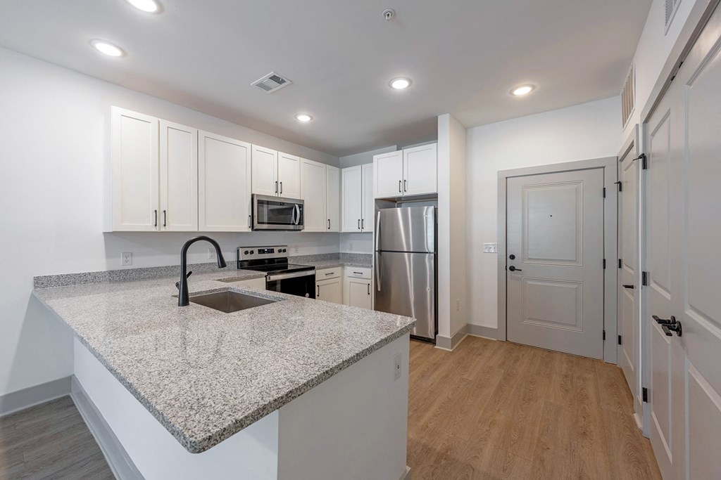 a kitchen with white cabinets and a granite counter top
