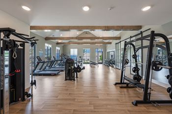 a gym with weights and other exercise equipment on a wood floor