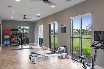a home gym with exercise equipment and large windows