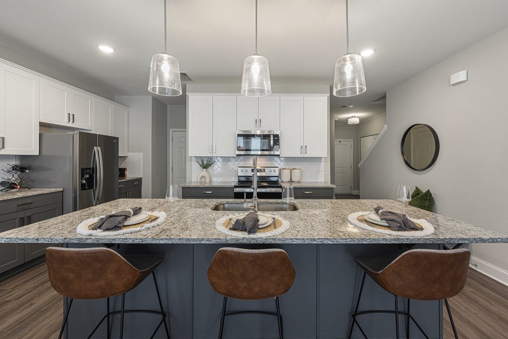 an open kitchen with a granite counter top and stools