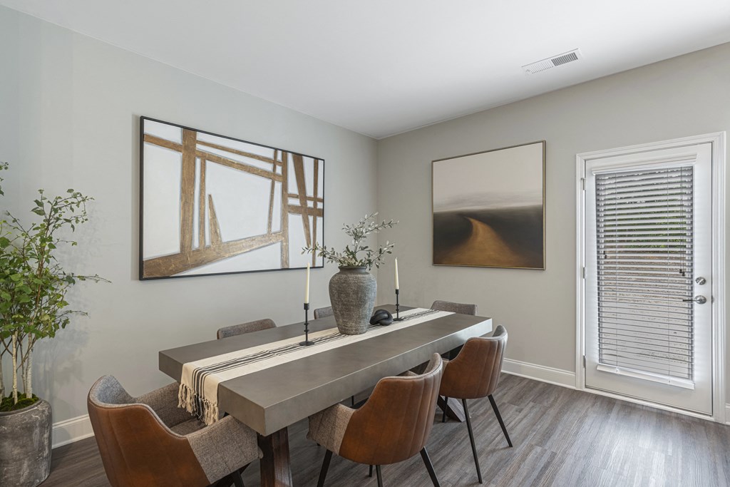 a dining room with a long table with chairs and a vase