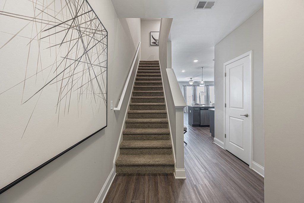 a stairway in a home with a white door and a painting on the wall