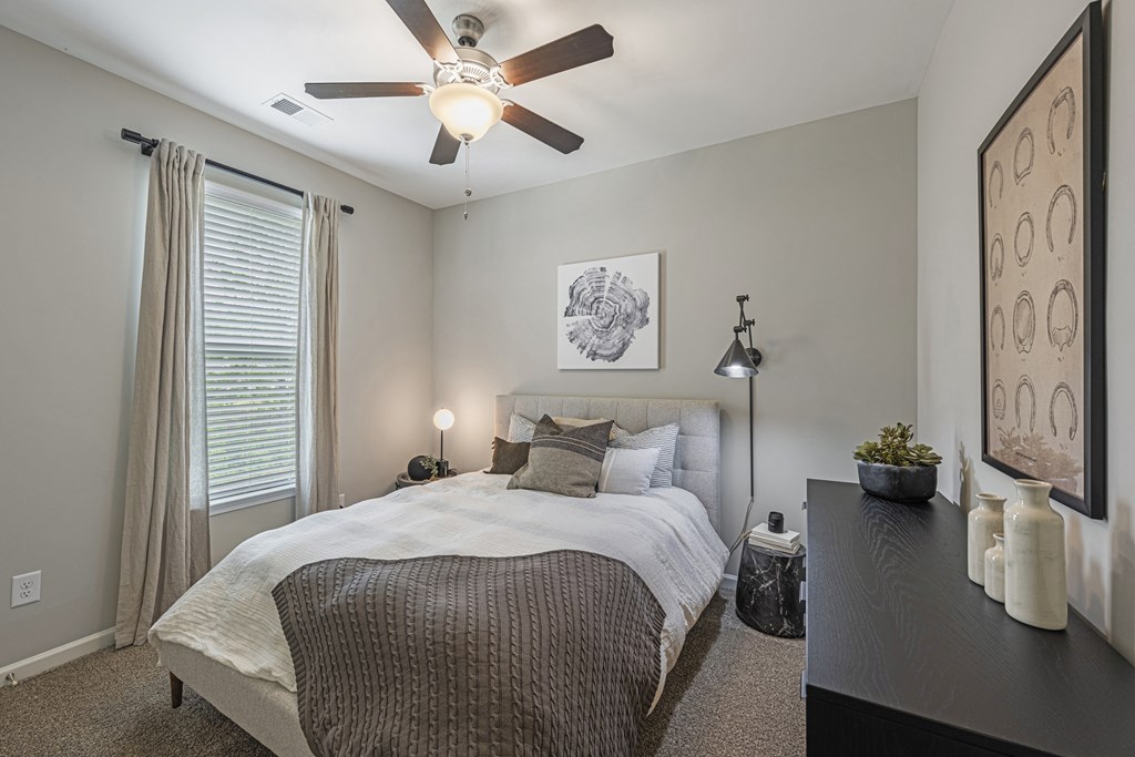 a bedroom with a large bed and a ceiling fan