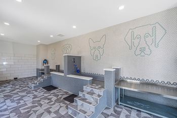 a view of the dog wash area with a large mosaic of dogs on the wall