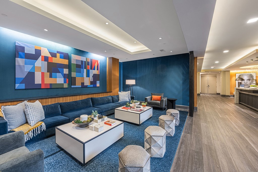 a living room with a blue wall and blue couches and tables