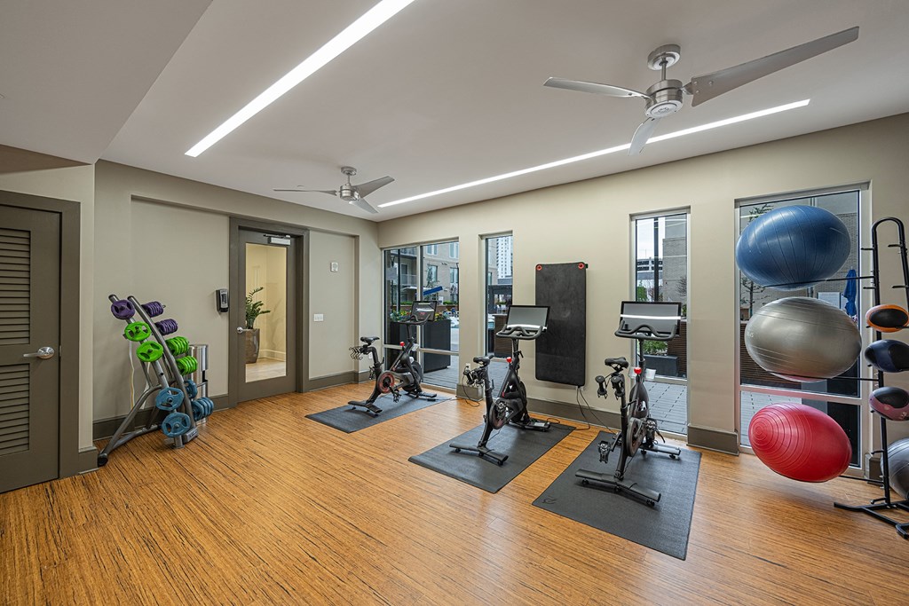 a gym with weights and exercise equipment on a wooden floor