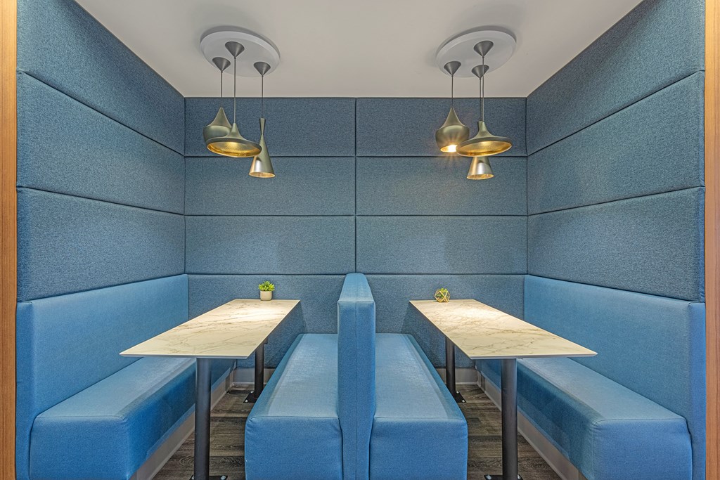 two tables and two benches in a blue booth