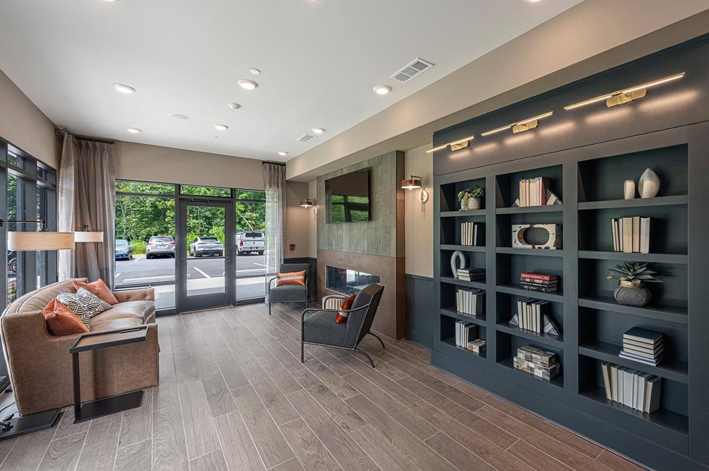 a lobby with couches and chairs and a book shelf