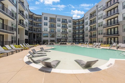 an empty swimming pool in front of an apartment building