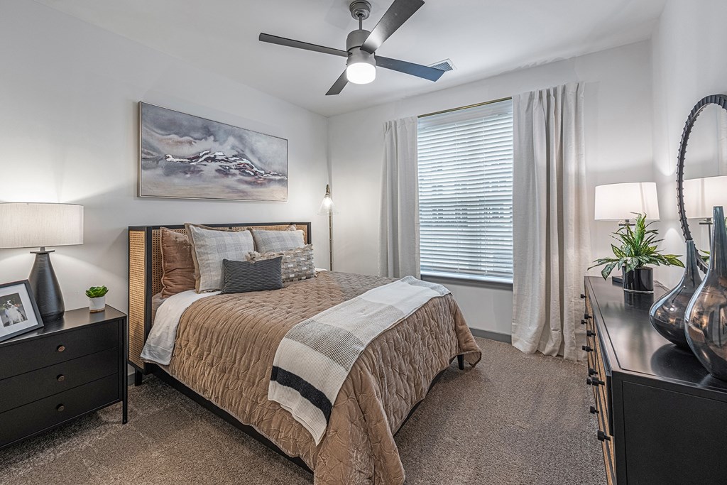 a bedroom with a bed and a ceiling fan