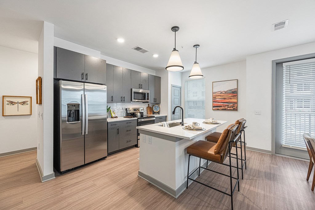 a kitchen with stainless steel appliances and a white island with stools