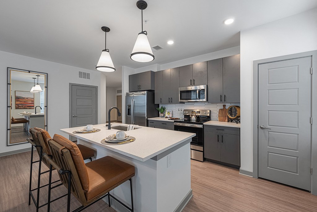 an open kitchen and dining area with a white counter top