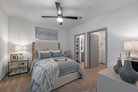 3-Bedroom Apartments in Chattanooga, TN - Populus Waterside - Carpeted Bedroom with Large Bed, Nightstands, Lamps, Private Bathroom, Spacious Closet, and Ceiling Fan.