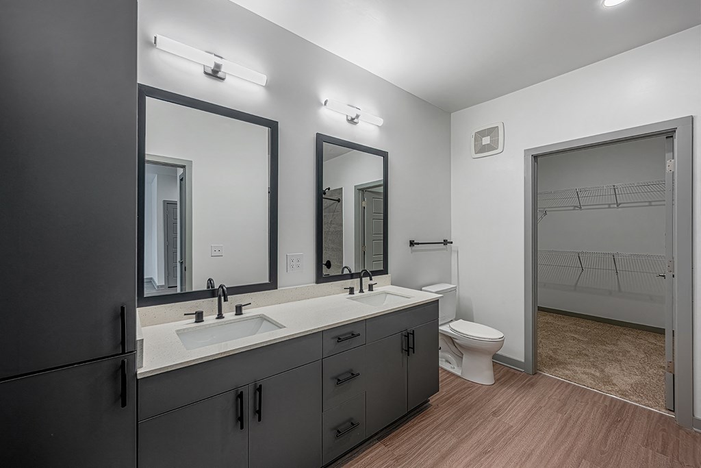a black and white bathroom with two sinks and a toilet