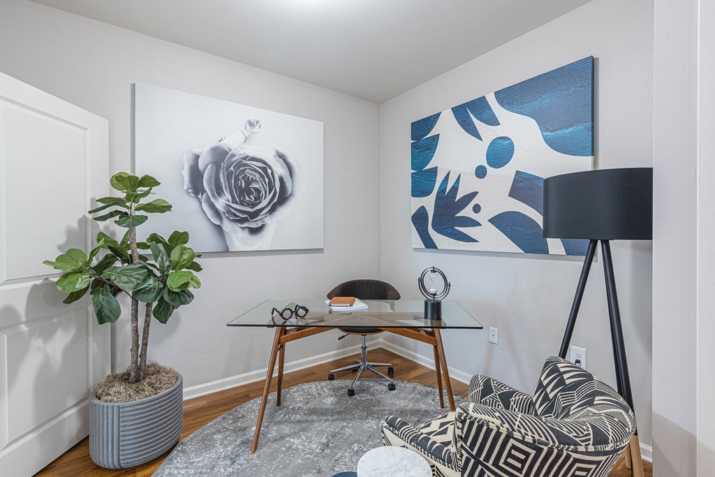a living room with a couch and a desk with a plant