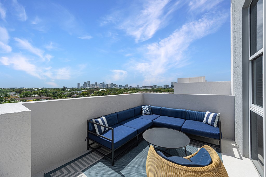 a balcony with a blue couch and a table