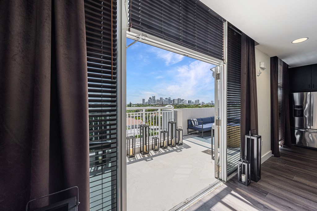 a living room with a balcony and a view of the city