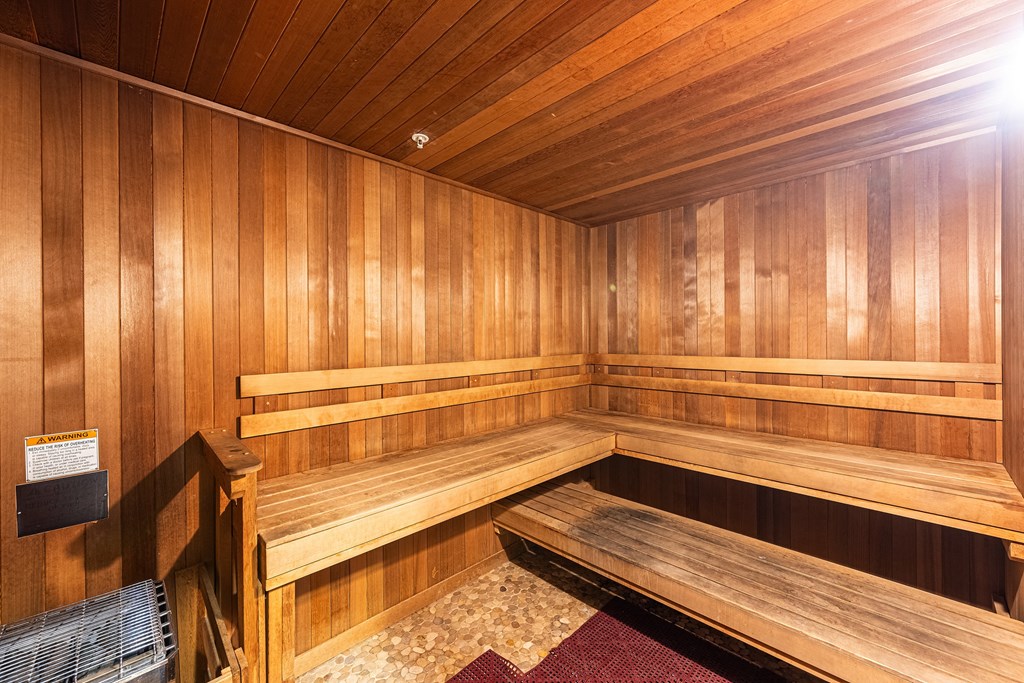 a wooden sauna with wooden benches and a chair