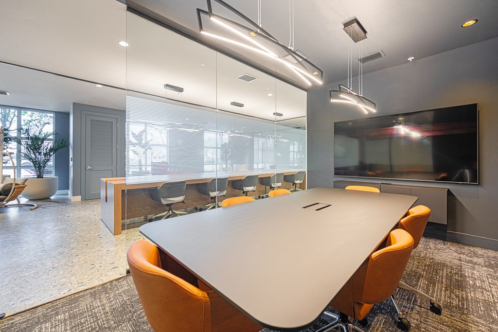 a conference room with a table and chairs and a television