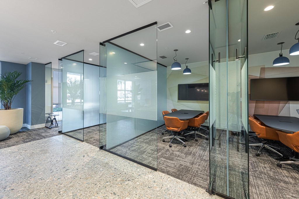 a conference room with glass walls and a table and chairs