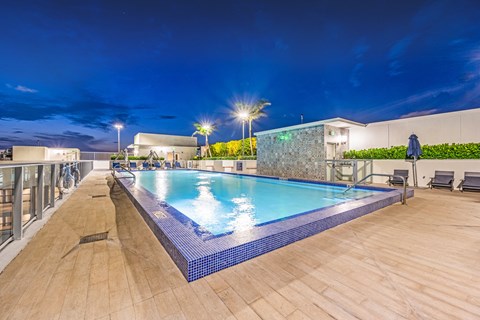 a swimming pool on the rooftop of a hotel at night