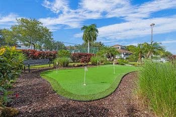 a mini golf course in a garden with a bench
