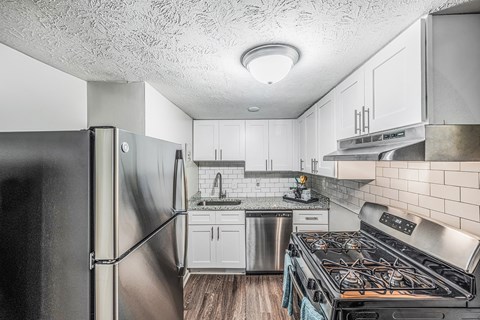 a kitchen with stainless steel appliances and white cabinets