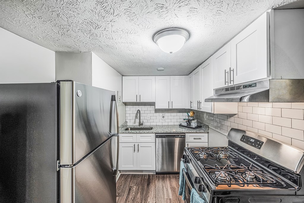 a kitchen with stainless steel appliances and white cabinets