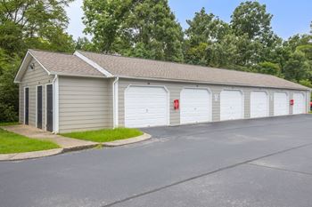 a three car garage with white doors and a gray roof