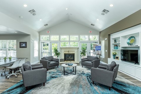 A living room with a fireplace and grey couches.