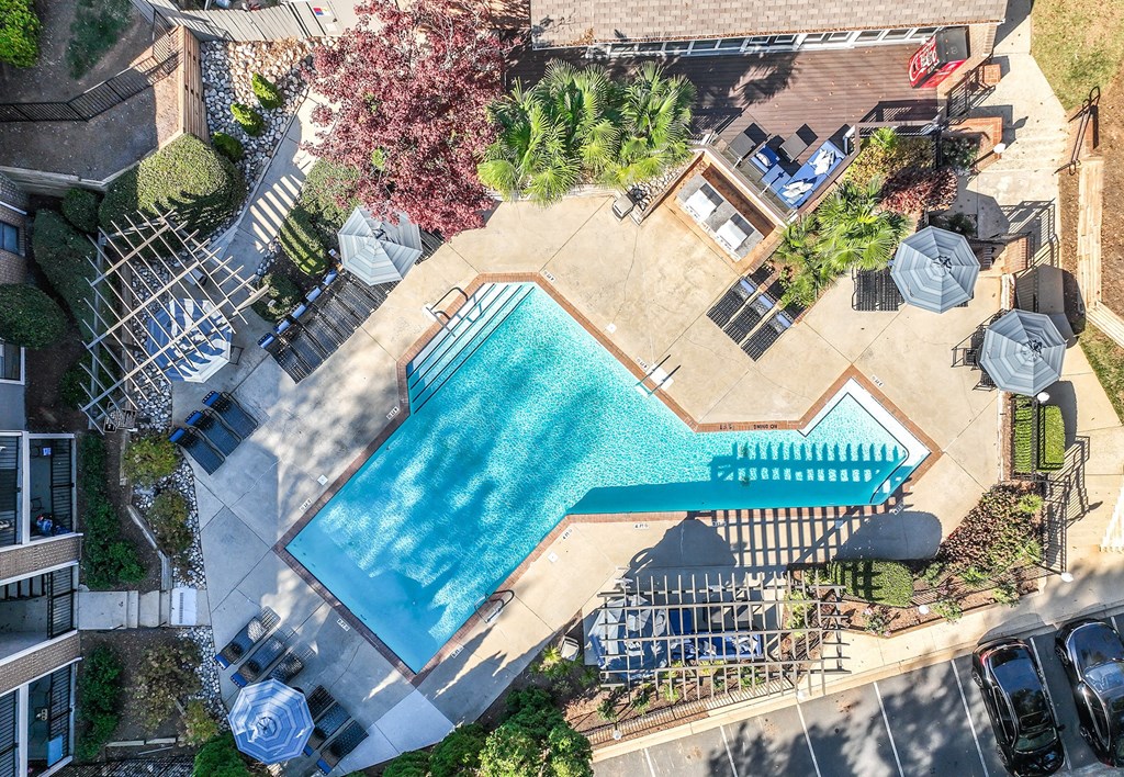 an aerial view of a swimming pool in a backyard with umbrellas