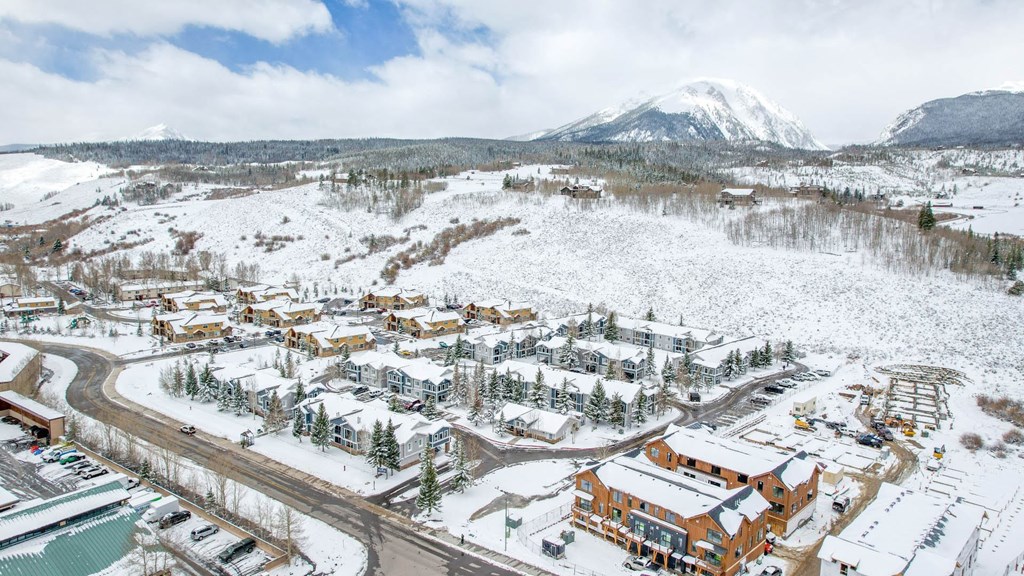 a city covered in snow with a mountain in the background