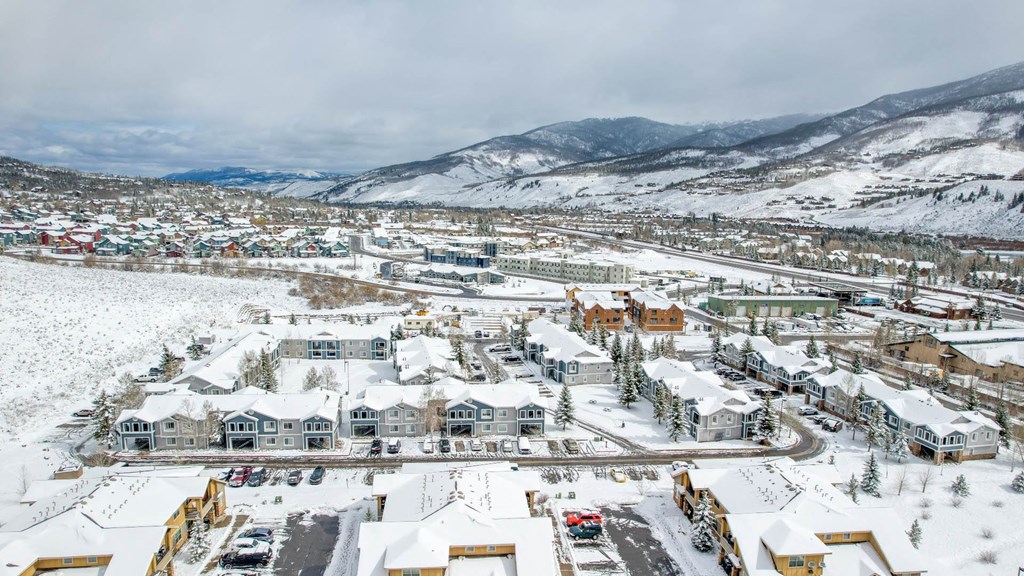 a city covered in snow with mountains in the background