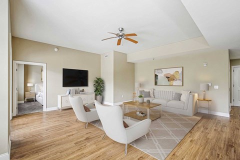 A living room with a white sofa and a wooden floor.