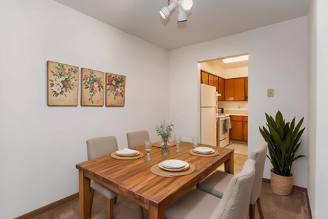 A dining room with a wooden table and chairs.