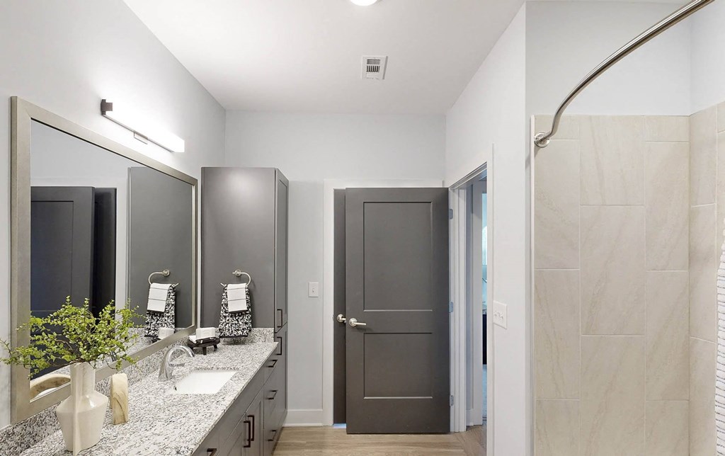 a bathroom with a shower and a sink and a mirror