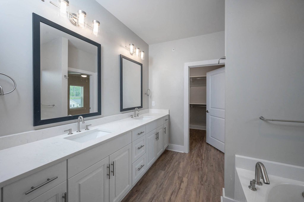 a white bathroom with two sinks and a mirror