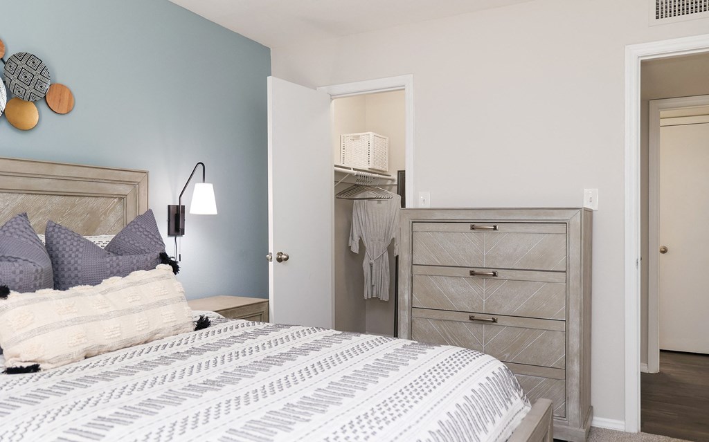 a bedroom with a bed and a dresser and a closet