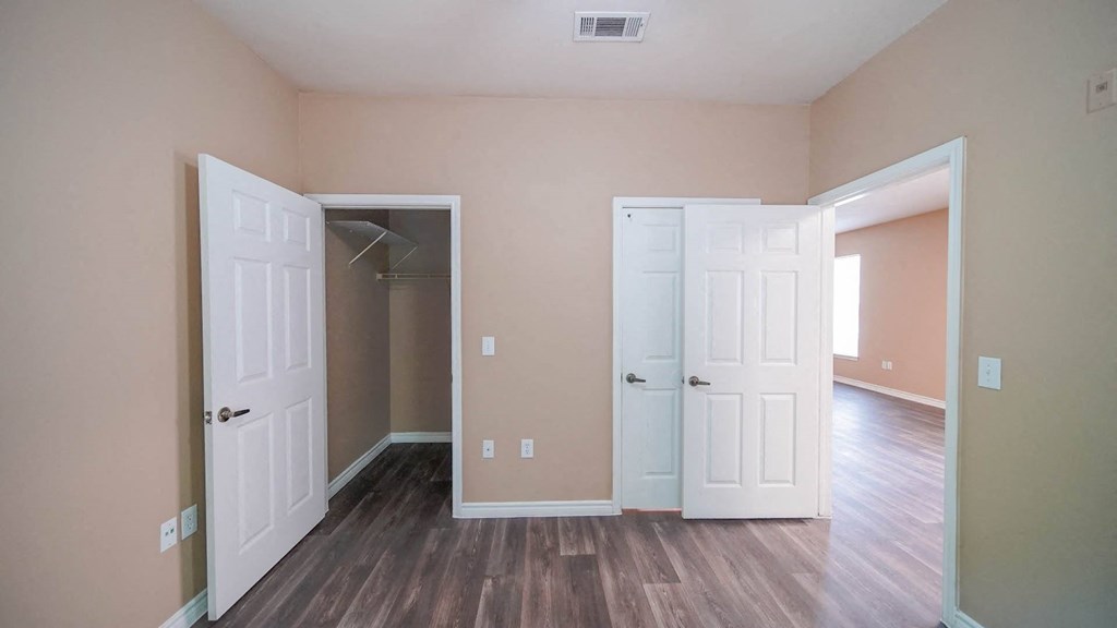 an empty room with two doors and a closet