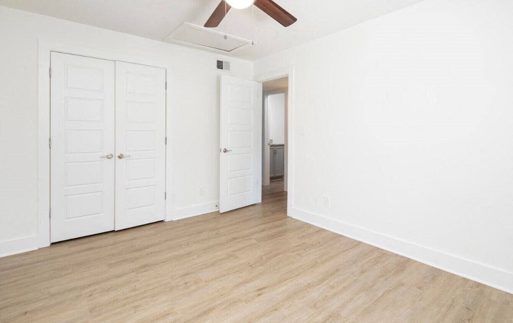 an empty living room with white walls and wood floors
